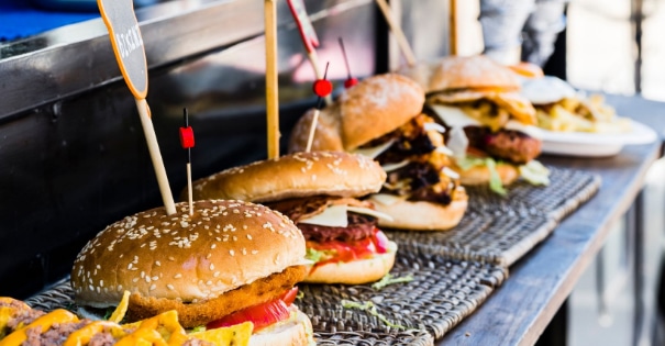 Burgers, chicken sandwhiches and fries on the edge of a grill