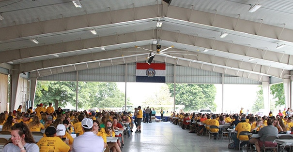 A large group of people sitting at tables in the Nucor Director's Pavilion