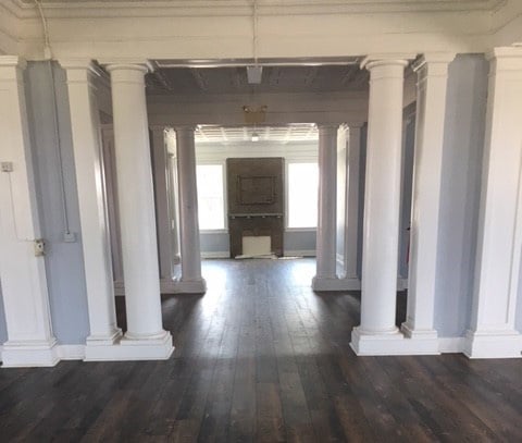 The inside of the Womans Building with white columns and dark floors